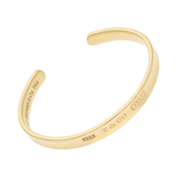 Pulsera de arillo ovalada abierta firma Tiffany & Co. en oro amarillo 18 kilates.