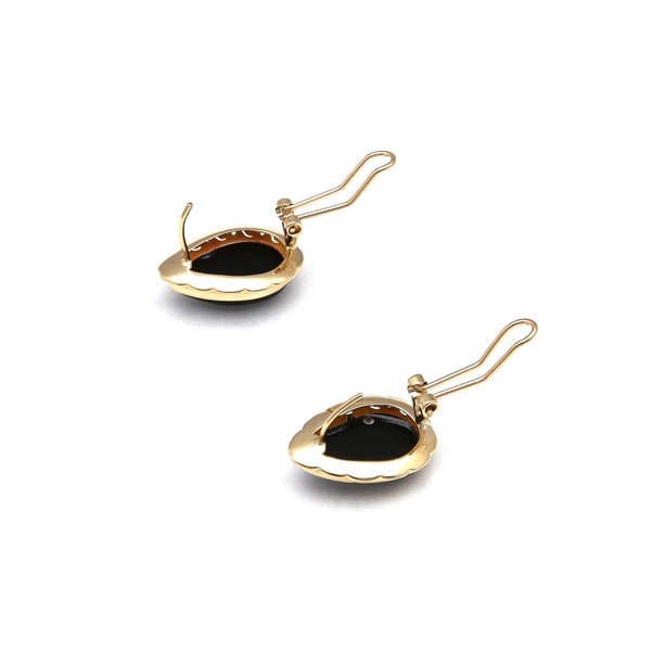Juego de anillo y aretes calados con ónix en oro amarillo 14 kilates.