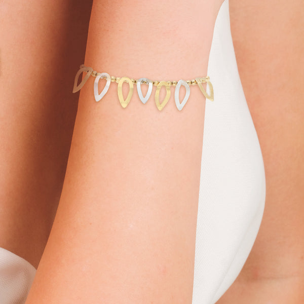 Pulsera eslabón combinado con colgantes en oro dos tonos 14 kilates.