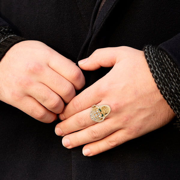 Anillo diseño especial motivo calavera con diamantes, esmeraldas y sintéticos en oro amarillo 18 kilates.