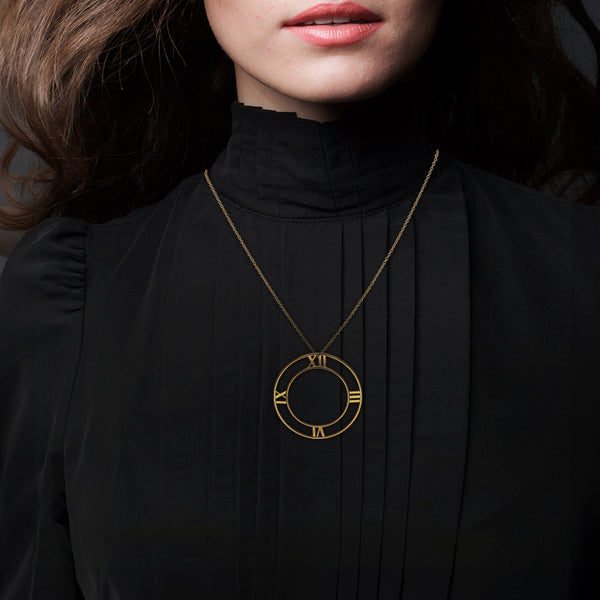 Collar eslabón cruzado y dije calado motivo números romanos firma Tiffany & Co. en oro amarillo 18 kilates.