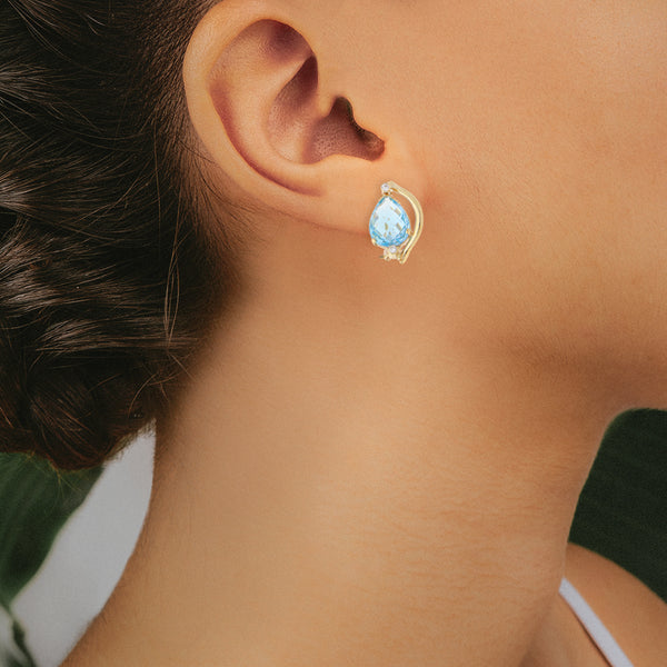 Aretes estilizados con diamantes y topacio azul en oro amarillo 14 kilates.