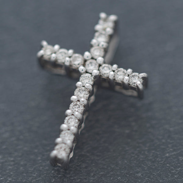 Cruz diseño especial con diamantes en oro blanco 14 kilates.