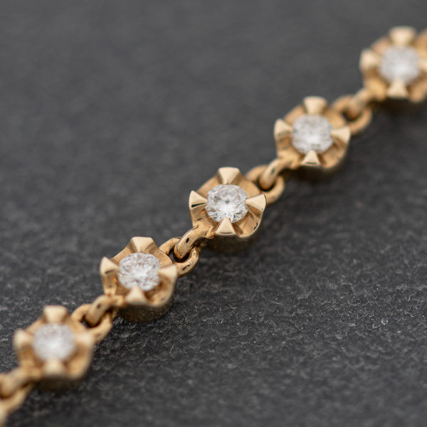 Pulsera eslabón cruzado con aplicaciones de diamantes en oro amarillo 14 kilates.