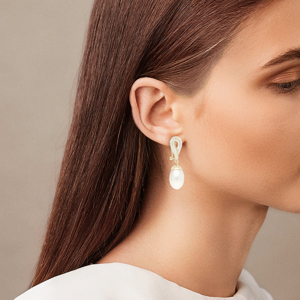 Aretes estilizados con colgantes, perlas y circonias en oro amarillo 14 kilates.