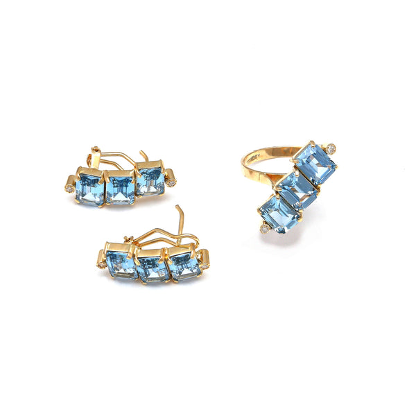 Juego de anillo y aretes estilizados con diamantes y topacios azules en oro amarillo 14 kilates.