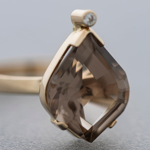 Juego de anillo y aretes estilizados con gemas y topacio ahumado en oro amarillo 14 kilates.