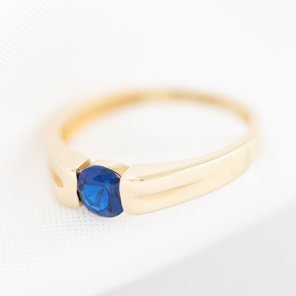 Anillo diseño especial con circonia azul en oro amarillo 14 kilates.