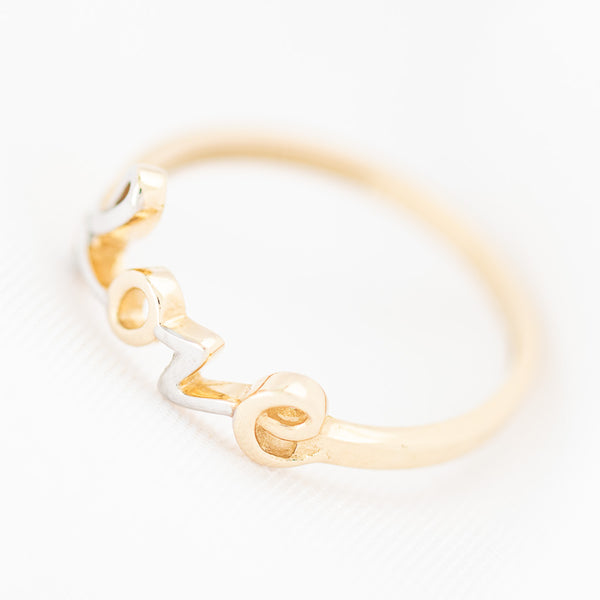 Anillo liso motivo letras en oro amarillo 14 kilates.