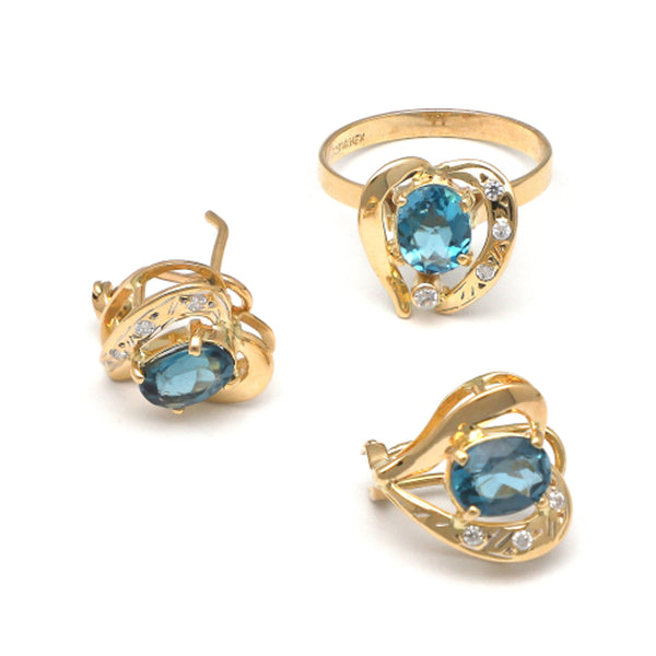 Juego de anillo y aretes estilizados motivo corazón con topacios London blue y circonias en oro amarillo 14 kilates.