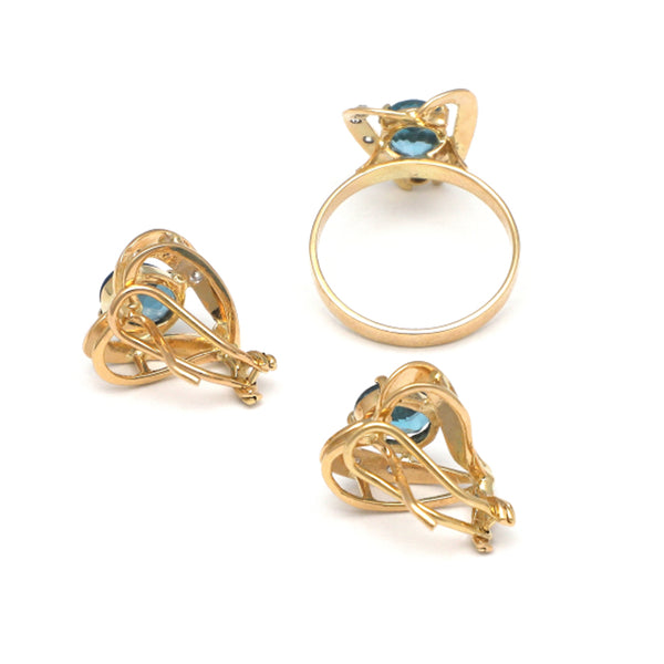 Juego de anillo y aretes estilizados motivo corazón con topacios London blue y circonias en oro amarillo 14 kilates.