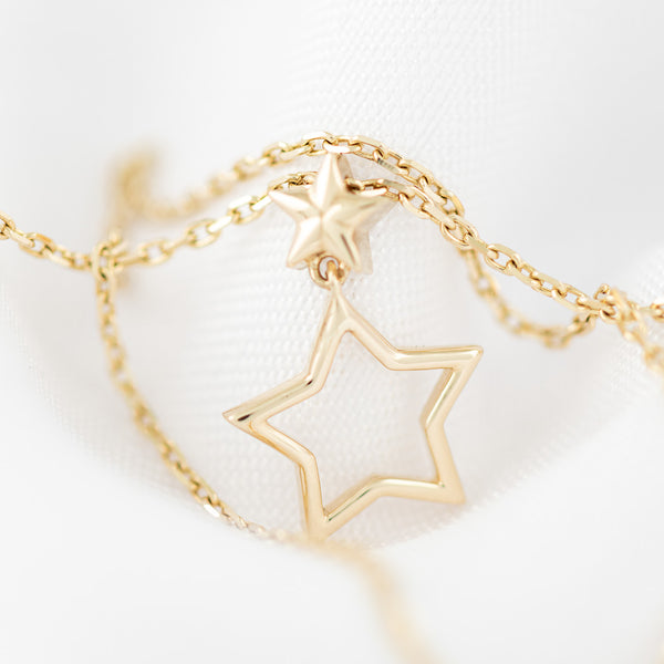 Gargantilla eslabón cruzado con colgante motivo estrellas en oro amarillo 14 kilates.