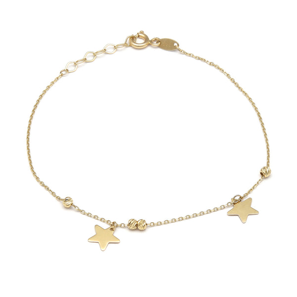 Pulsera eslabón cruzado con aplicaciones motivo esferas y estrellas en oro amarillo 14 kilates.