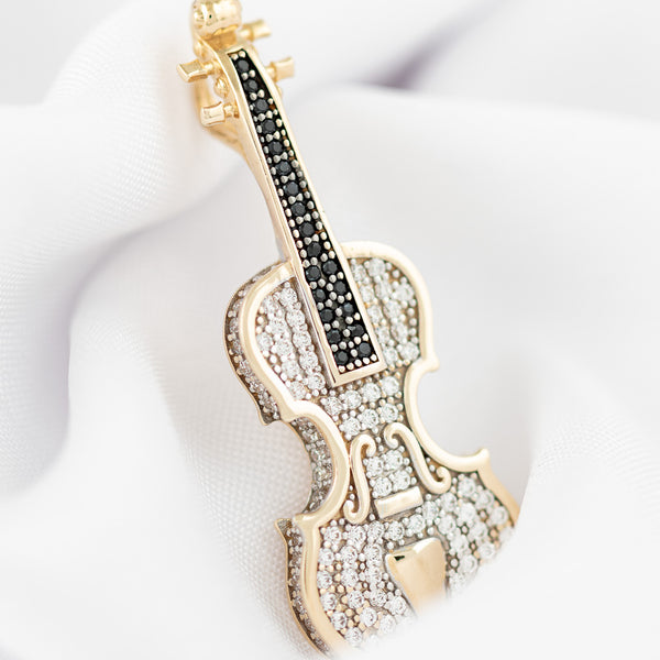 Dije diseño especial motivo violín con circonias en oro amarillo 14 kilates.