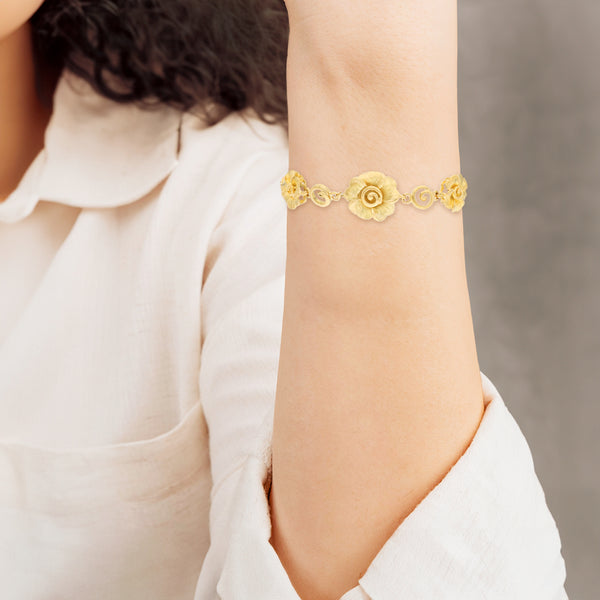 Pulsera eslabón combinado con aplicaciones motivo flor en oro amarillo 24 kilates.