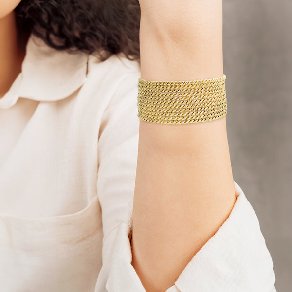 Brazalete de once hilos abierto en oro amarillo 18 kilates.