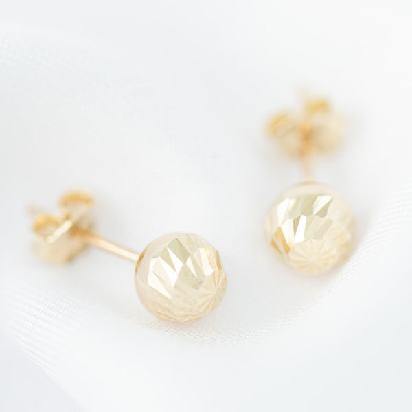 Aretes huecos motivo esferas en oro amarillo 14 kilates.