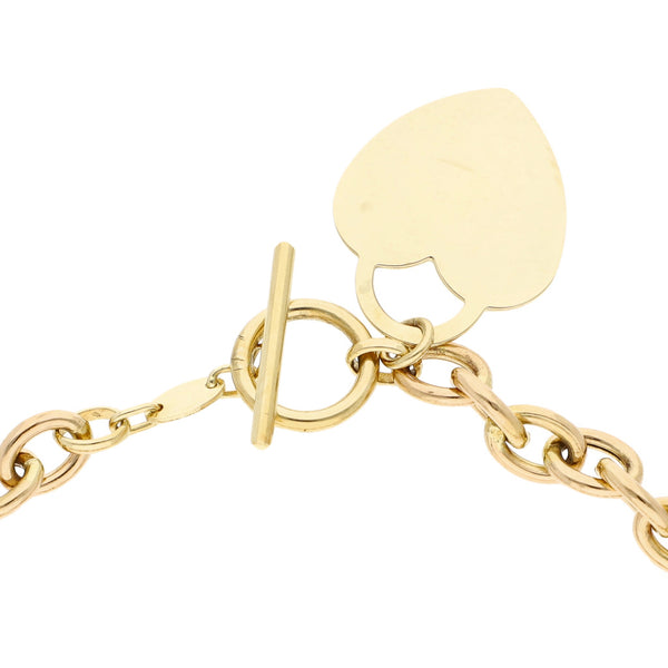 Pulsera eslabón cruzado con colgante motivo corazón en oro amarillo 14 kilates.