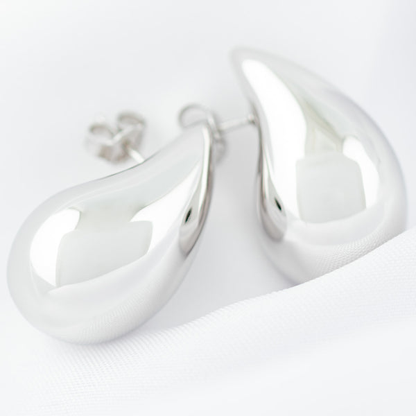 Aretes huecos motivo gota en oro blanco 14 kilates.