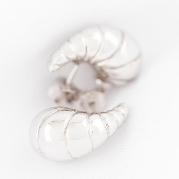 Aretes huecos motivo caracol en oro blanco 14 kilates.