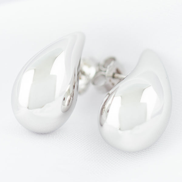 Aretes huecos motivo gota en oro blanco 14 kilates.