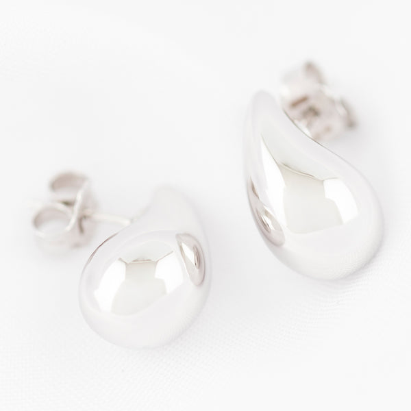 Aretes huecos motivo gota en oro blanco 14 kilates.