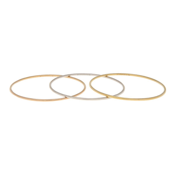 Tres pulseras de arillo rígidas firma Tiffany & Co. en oro tres tonos 18 kilates.