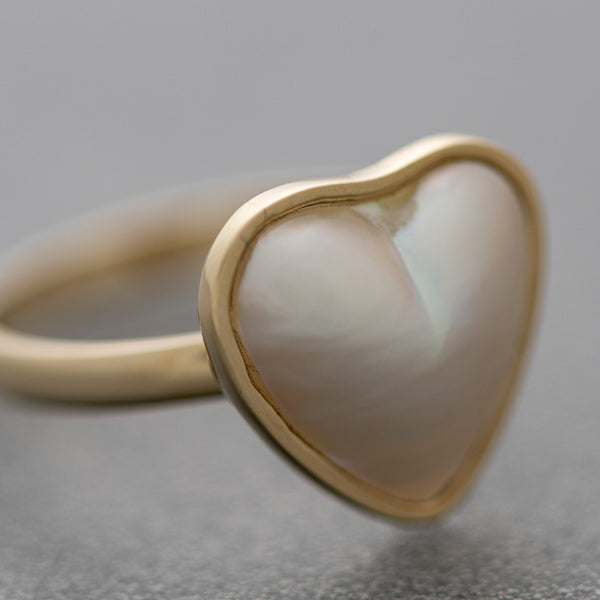 Juego de anillo y aretes diseño especial motivo corazón con media perla en oro amarillo 14 kilates.