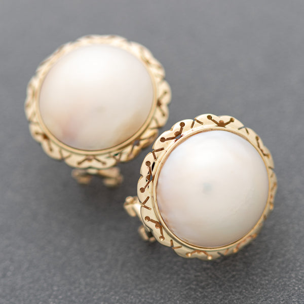 Aretes calados con media perla en oro amarillo 14 kilates.