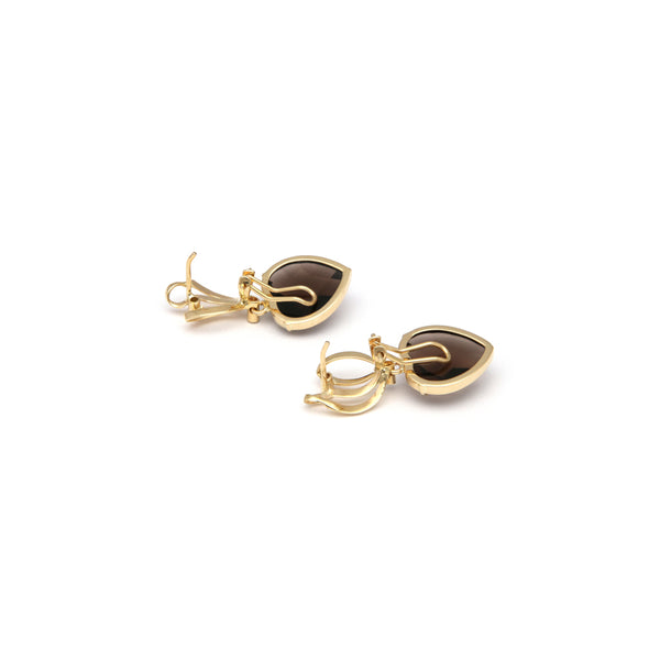 Juego de anillo y aretes estilizados con colgantes de diamantes y topacios en oro amarillo 14 kilates.