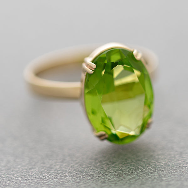 Juego de anillo y aretes diseño especial con colgantes de peridotos y sintéticos en oro amarillo 14 kilates.