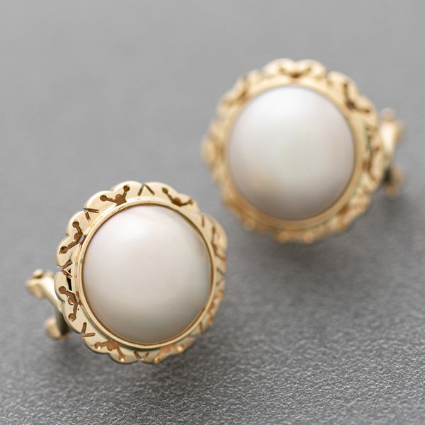 Aretes calados con media perla en oro amarillo 14 kilates.