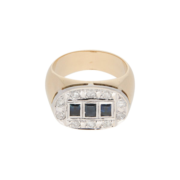 Anillo tipo sello con aplicación en plata paladio, diamantes y zafiros en oro amarillo 12 kilates.