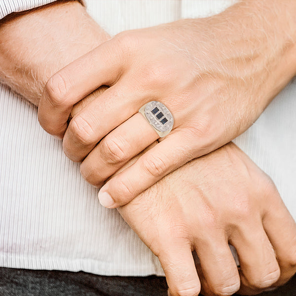 Anillo tipo sello con aplicación en plata paladio, diamantes y zafiros en oro amarillo 12 kilates.