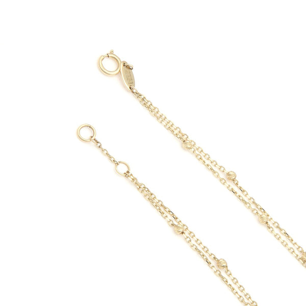 Pulsera dos hilos eslabón cruzado con aplicaciones motivo rombo y corazón en oro amarillo 14 kilates.