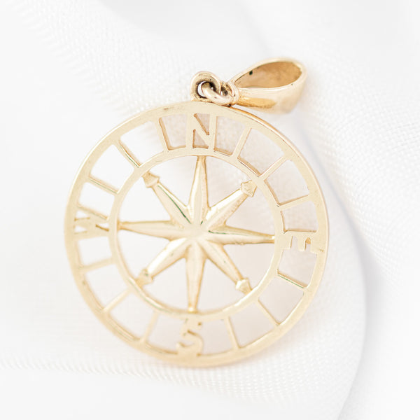 Dije calado motivo rosa de vientos en oro amarillo 14 kilates.