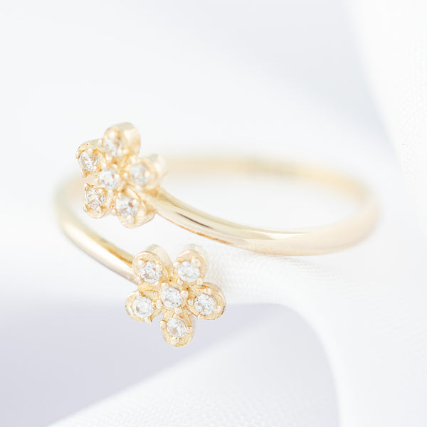 Anillo abierto motivo flores con circonias en oro amarillo 14 kilates.
