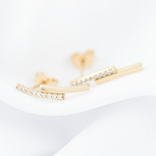 Aretes estilizados con circonias en oro amarillo 14 kilates.
