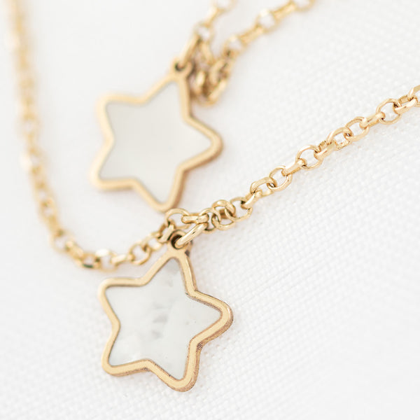 Juego de gargantilla eslabón cruzado y aretes con colgantes motivo estrellas de madreperla en oro amarillo 14 kilates.
