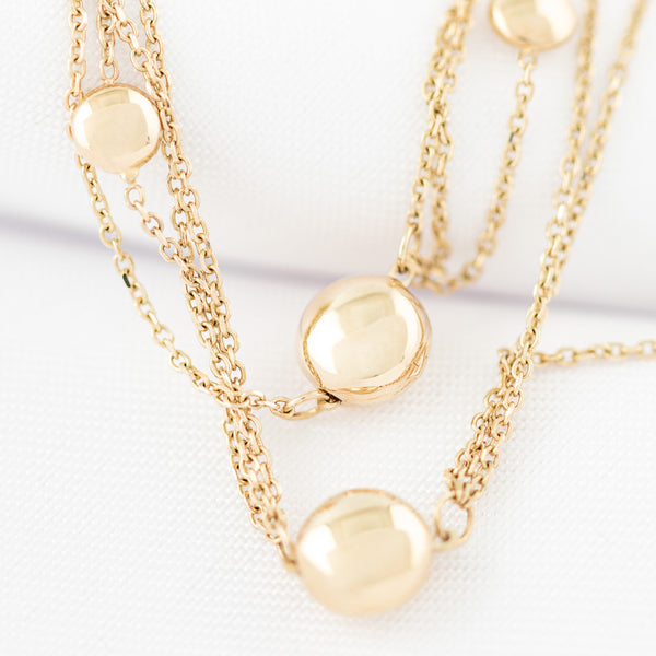 Juego de gargantilla, pulsera eslabón cruzado y aretes con colgantes y cuentas en oro amarillo 14 kilates.