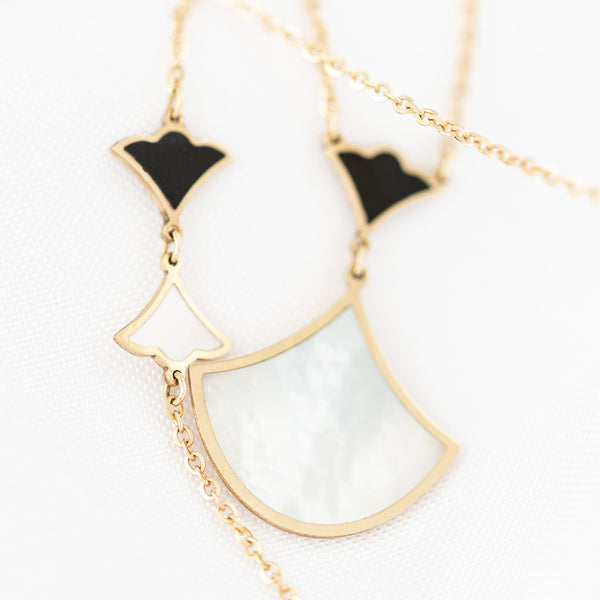 Juego de gargantilla, pulsera eslabón cruzado y aretes con colgantes motivo abanico, madre perla y sintéticos en oro amarillo 14 kilates.