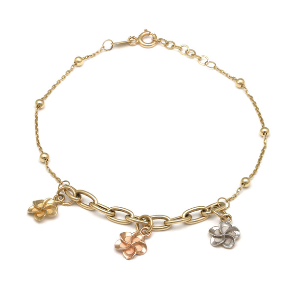Pulsera eslabón cruzado con aplicaciones y colgantes motivo flor en oro tres tonos 14 kilates.