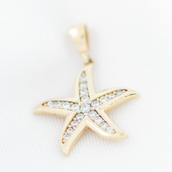 Dije diseño especial motivo estrella de mar con circonias en oro amarillo 14 kilates.