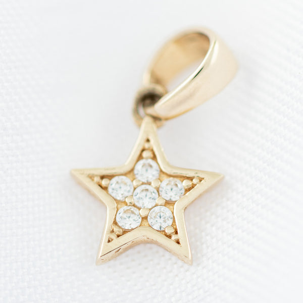 Dije diseño especial motivo estrella con circonias en oro amarillo 14 kilates.
