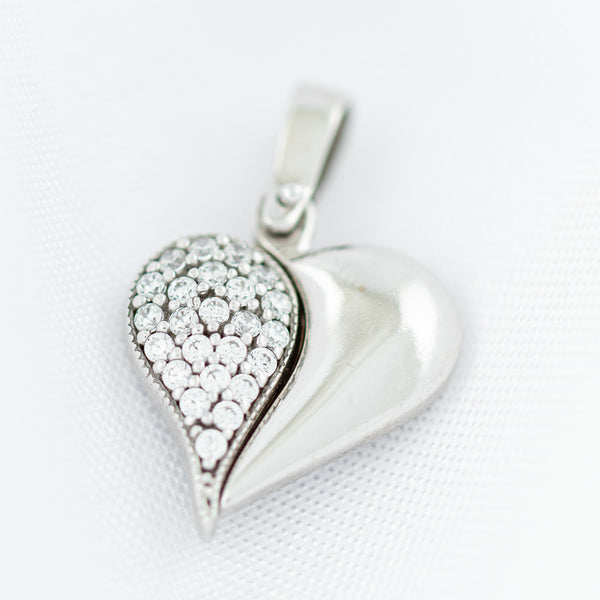 Dije articulado motivo corazón con circonias en oro blanco 14 kilates.