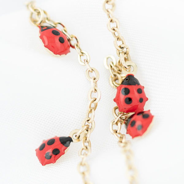 Pulsera eslabón cruzado con colgantes motivo catarinas con esmalte en oro amarillo 14 kilates.