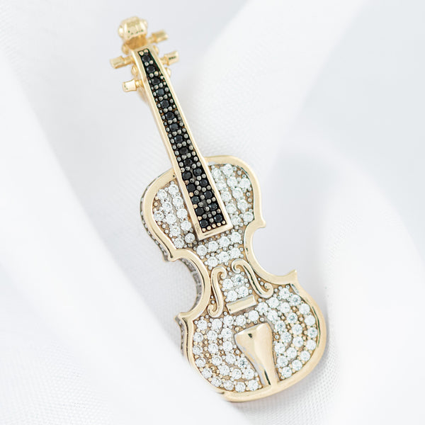 Dije hueco motivo violín con sintéticos en oro amarillo 14 kilates.