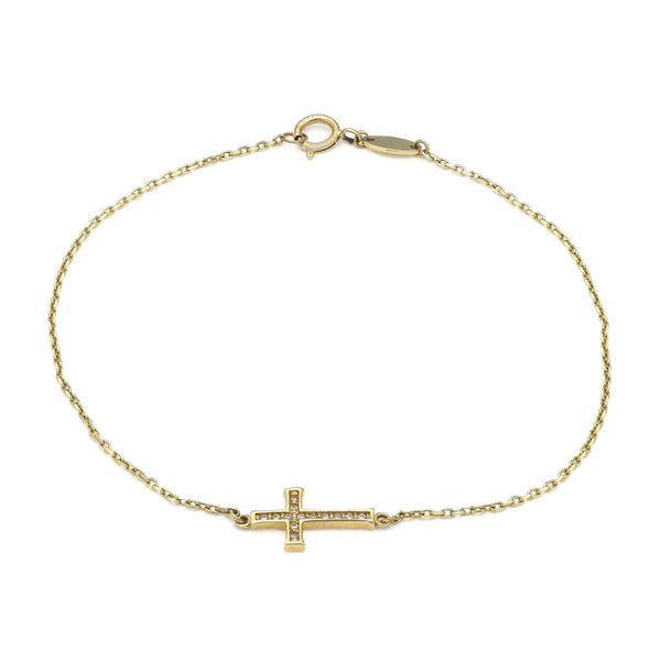 Pulsera eslabón cruzado con aplicación motivo cruz y circonias en oro amarillo 14 kilates.