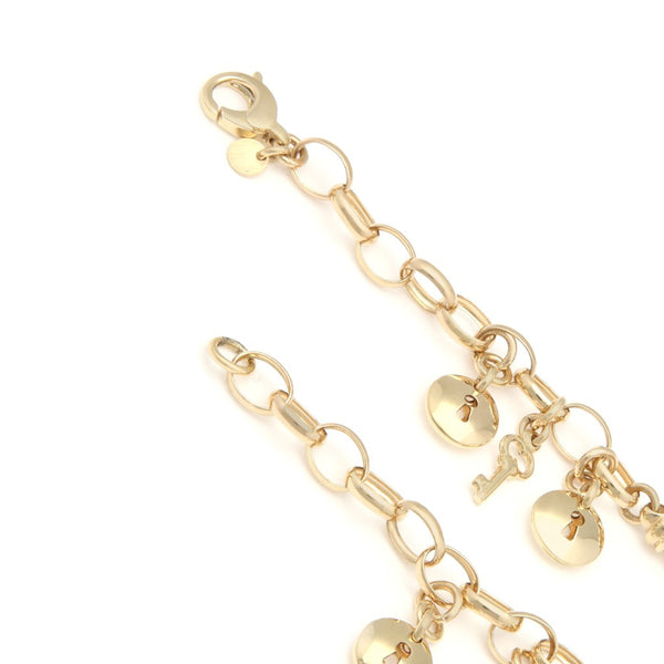 Pulsera eslabón combinado con colgantes motivo llave y cerradura en oro amarillo 14 kilates.