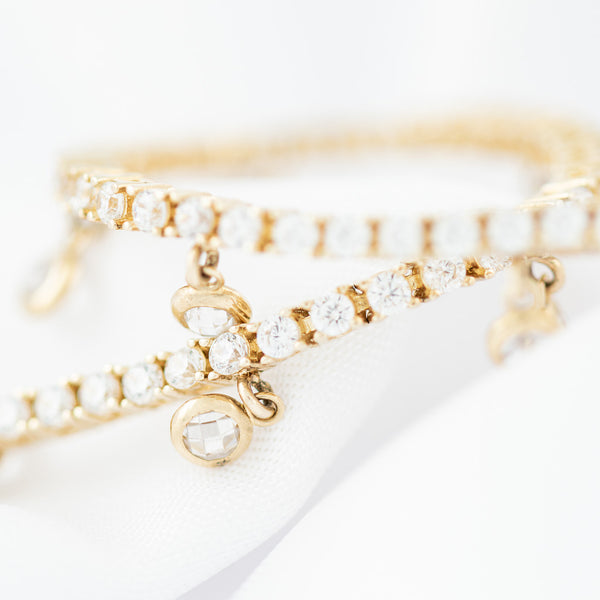 Pulsera eslabón articulado con aplicaciones y colgantes de circonias en oro amarillo 14 kilates.
